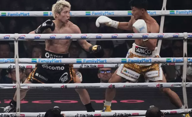 Naoya Inoue of Japan, left, fights Junto Nakatani of Japan during second round of a boxing match for the WBA, WBC, IBF and WBO super bantamweight world title in Tokyo, Saturday, May 2, 2026. (AP Photo/Hiro Komae)