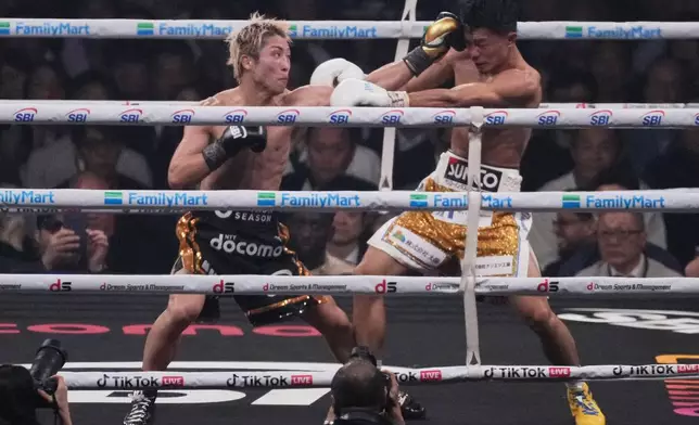 Naoya Inoue of Japan, left, punches Junto Nakatani of Japan during the twelfth round of a boxing match for the WBA, WBC, IBF and WBO super bantamweight world title in Tokyo, Saturday, May 2, 2026. (AP Photo/Hiro Komae)