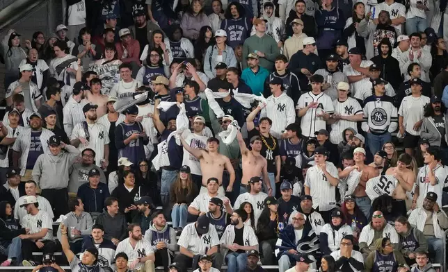 Shirtless fans of the New York Yankees react during the ninth inning of a baseball game against the Tampa Bay Rays, Friday, May 22, 2026, in New York. (AP Photo/Yuki Iwamura)