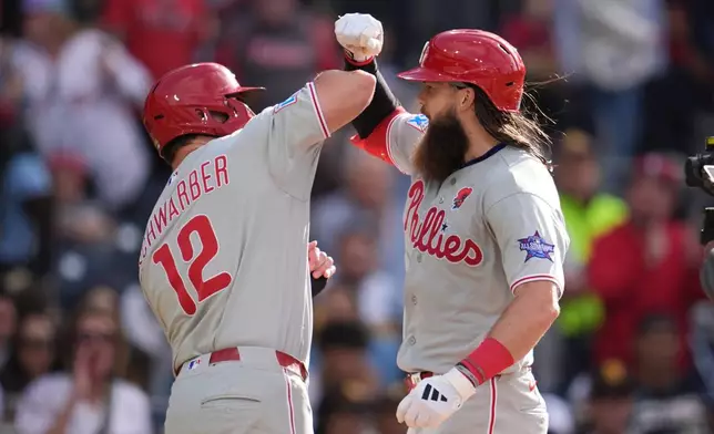 Philadelphia Phillies' Brandon Marsh, right, celebrates with teammate Kyle Schwarber after hitting a two-run home run during the seventh inning of a baseball game against the San Diego Padres Monday, May 25, 2026, in San Diego. (AP Photo/Gregory Bull)