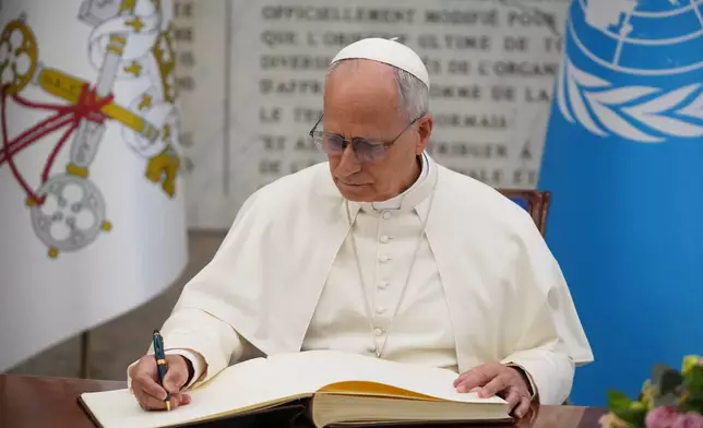 FILE - Pope Leo XIV signs the FAO Golden Book register of honor as he attends a ceremony marking the 80th anniversary of World Food Day at the FAO headquarters in Rome, Thursday, Oct. 16, 2025. (AP Photo/Alessandra Tarantino, File)
