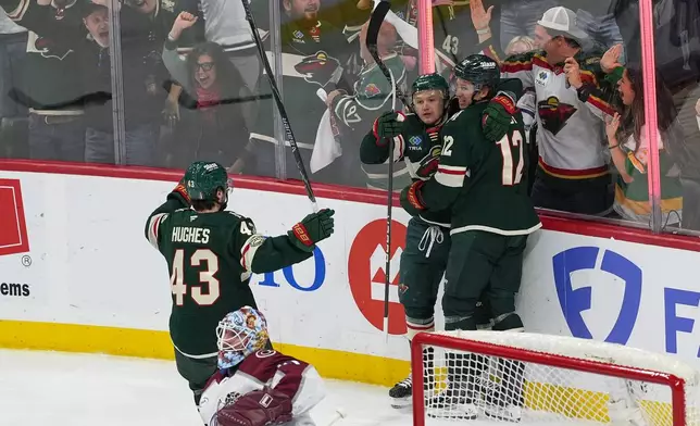 Minnesota Wild left wing Kirill Kaprizov, second from right, celebrates with defenseman Quinn Hughes (43) and left wing Matt Boldy (12) after scoring during the first period of Game 3 of an NHL Stanley Cup hockey second-round playoff series against the Colorado Avalanche, Saturday, May 9, 2026, in St. Paul, Minn. (AP Photo/Abbie Parr)
