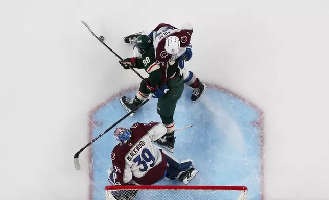 Minnesota Wild right wing Ryan Hartman (38) tries to gain control of the puck as Colorado Avalanche defenseman Brett Kulak (27) and goaltender MacKenzie Blackwood (39) defend during the third period of Game 3 of an NHL Stanley Cup hockey second-round playoff series Saturday, May 9, 2026, in St. Paul, Minn. (AP Photo/Abbie Parr)