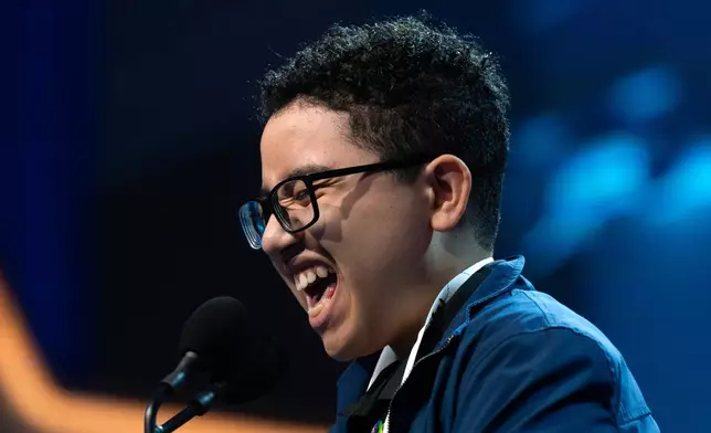 Logan Cox, 14, of Homestead, Fla., spells his word as he competes during the preliminary round of the Scripps National Spelling Bee at DAR Constitution Hall, Tuesday, May 26, 2026, in Washington. (AP Photo/Jose Luis Magana)