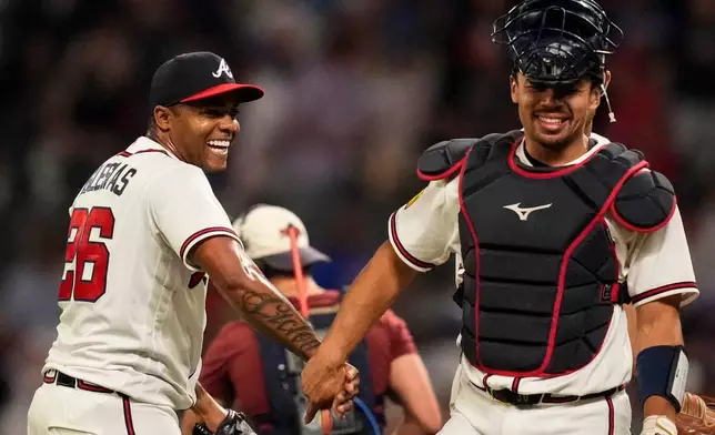 Atlanta Braves pitcher Raisel Iglesias celebrates a win over the Chicago Cubs with Drake Baldwin after a baseball game, Wednesday, May 13, 2026, in Atlanta. (AP Photo/Mike Stewart)