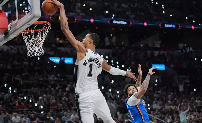 San Antonio Spurs forward Victor Wembanyama (1) scores a basket against Oklahoma City Thunder guard Kenrich Williams during the second half of Game 4 in the Western Conference finals NBA basketball playoffs series in San Antonio, Sunday, May 24, 2026. (AP Photo/Eric Gay)