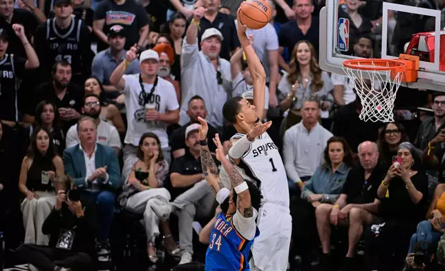San Antonio Spurs forward Victor Wembanyama (1) dunks on Oklahoma City Thunder guard Kenrich Williams during the second half of Game 4 in the Western Conference finals NBA basketball playoffs series in San Antonio, Sunday, May 24, 2026. (AP Photo/Darren Abate)