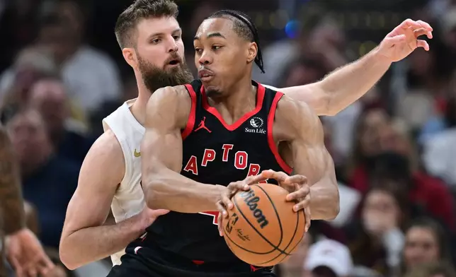 Toronto Raptors forward Scottie Barnes drives on Cleveland Cavaliers forward Dean Wade during the second half in Game 5 of a first-round NBA playoffs basketball series, Wednesday, April 29, 2026, in Cleveland. (AP Photo/David Dermer)