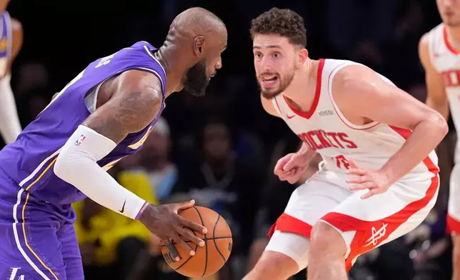 Los Angeles Lakers forward LeBron James, left, tries to get by Houston Rockets center Alperen Sengun during the second half in Game 5 of a first-round NBA playoffs basketball series Wednesday, April 29, 2026, in Los Angeles. (AP Photo/Mark J. Terrill)