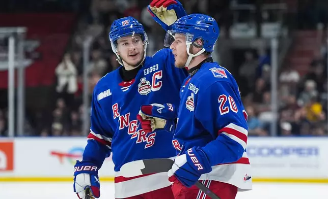 Kitchener Rangers' Cameron Reid (18) and Gabriel Chiarot (20) celebrate after Chiarot's goal during the second period of a Memorial Cup hockey game against the Everett Silvertips in Kelowna, British Columbia, Monday, May 25, 2026. (Darryl Dyck/The Canadian Press via AP)