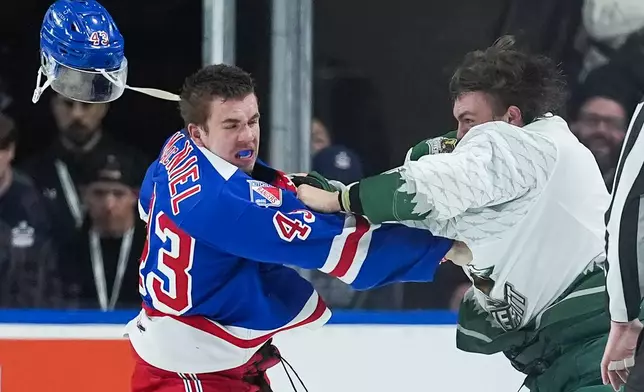 Kitchener Rangers' Andrew MacNiel, left, loses his helmet as he and Everett Silvertips' Jaxsin Vaughan fight during the second period of a Memorial Cup hockey game in Kelowna, British Columbia, Monday, May 25, 2026. (Darryl Dyck/The Canadian Press via AP)