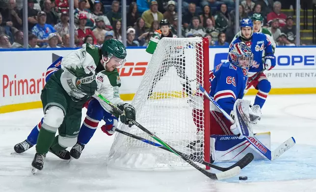 Everett Silvertips' Jesse Heslop, front left, attempts a wraparound against Kitchener Rangers goalie Christian Kirsch (65) during the first period of a Memorial Cup hockey game in Kelowna, British Columbia, Monday, May 25, 2026. (Darryl Dyck/The Canadian Press via AP)