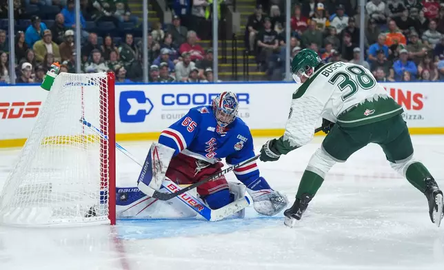 Kitchener Rangers goalie Christian Kirsch (65) stops Everett Silvertips' Shea Busch (38) during the first period of a Memorial Cup hockey game in Kelowna, British Columbia, Monday, May 25, 2026. (Darryl Dyck/The Canadian Press via AP)