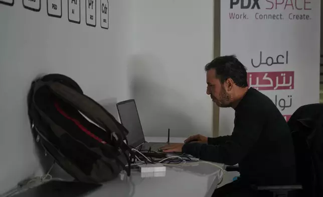 Palestinian programmer Tarik Zaeem, 44, works on his computer at a coworking space in Gaza City, March 8, 2026. (AP Photo/Abdel Kareem Hana)