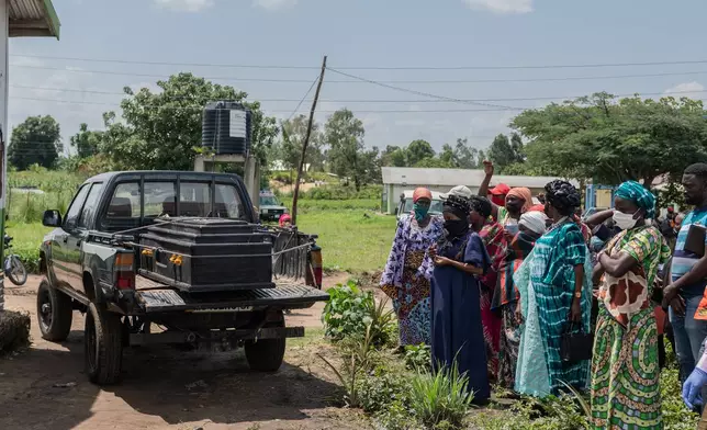 Relatives stand next to a pick-up truck carrying the coffin of a person who died of Ebola at a health center in Rwampara, Congo, Wednesday, May 20, 2026. (AP Photo/Moses Sawasawa)