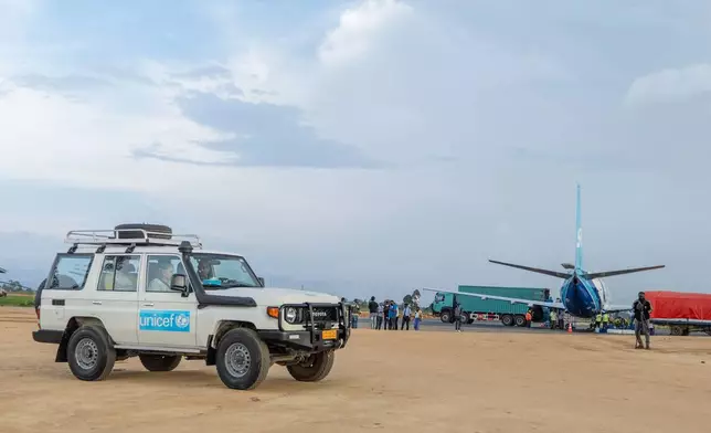 People wait in a UNICEF vehicle at Bunia National Airport ahead of the arrival of supplies as part of the response to the Ebola outbreak in Bunia, Congo, Tuesday, May 19, 2026. (AP Photo/Moses Sawasawa)