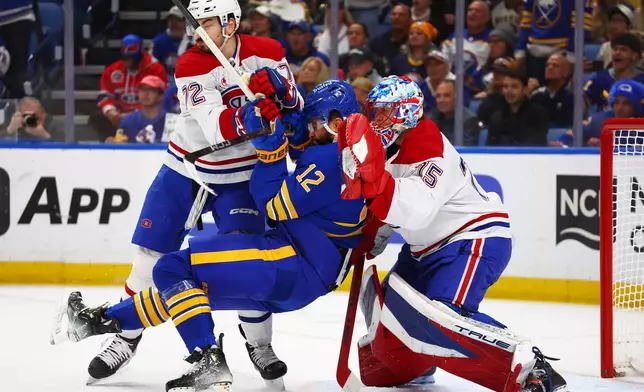 Buffalo Sabres left wing Jordan Greenway (12) is checked by Montreal Canadiens defenseman Arber Xhekaj (72) in front of goaltender Jakub Dobes (75) during the first period in Game 5 of a second-round NHL hockey Stanley Cup playoff series, Thursday, May 14, 2026, in Buffalo, N.Y. (AP Photo/Jeffrey T. Barnes)