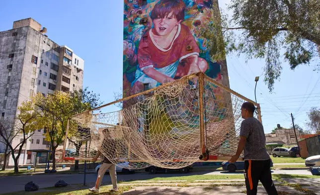 Workers from the Grandoli football club carry a goalpost to the pitch for children's soccer matches in Rosario, Argentina, Saturday, May 2, 2026. (AP Photo/Rodrigo Abd)