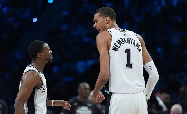 San Antonio Spurs forward Victor Wembanyama (1) celebrates a score with guard De'aaron Fox (4) during the first half of Game 6 of an NBA basketball second-round playoffs series in Minneapolis, Friday, May 15, 2026. (AP Photo/Abbie Parr)