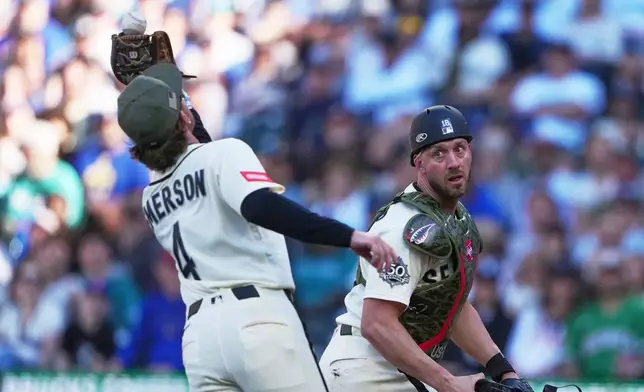 Seattle Mariners third baseman Colt Emerson catches a fly ball from San Diego Padres' Freddy Fermin as Mariners catcher Mitch Garver, right, looks on during the fifth inning of a baseball game, Sunday, May 17, 2026, in Seattle. (AP Photo/Lindsey Wasson)