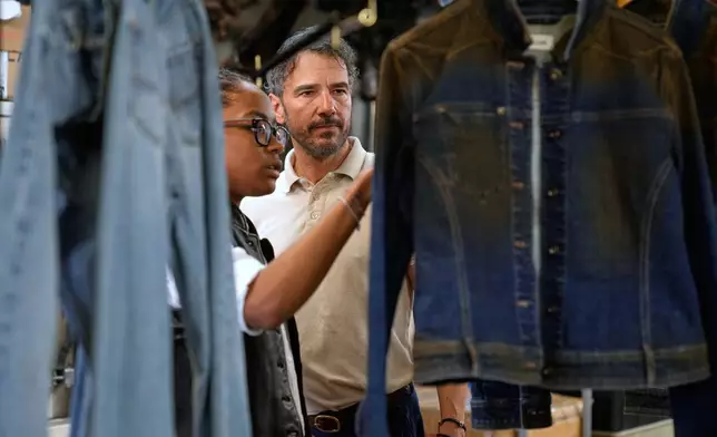 Bill Curtin, owner of BPD Washhouse, looks over some samples at his denim processing facility in Jersey City, N.J., Tuesday, May 5, 2026. (AP Photo/Seth Wenig)