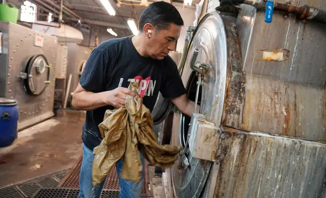 Ruben Revollo inspects some samples after washing them at the BPD Washhouse, a denim processing facility, in Jersey City, N.J., Tuesday, May 5, 2026. (AP Photo/Seth Wenig)