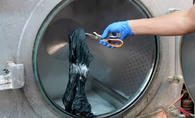 A piece of clothing is examined for color during a wash at the BPD Washhouse, a denim processing facility, in Jersey City, N.J., Tuesday, May 5, 2026. (AP Photo/Seth Wenig)
