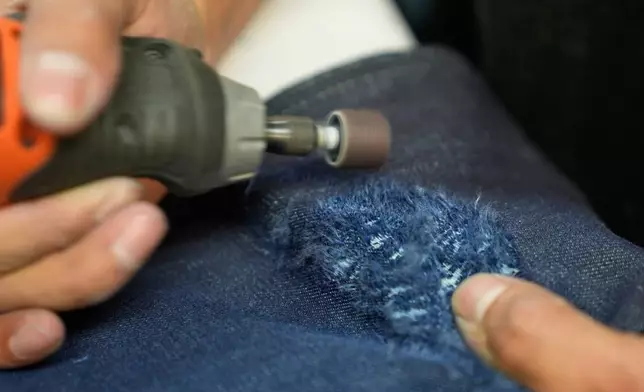 Bryan Morales Ibarra distresses denim by hand at the BPD Washhouse, a denim processing facility, in Jersey City, N.J., Tuesday, May 5, 2026. (AP Photo/Seth Wenig)