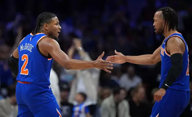 New York Knicks' Miles McBride, left, and Jalen Brunson celebrate during the first half of Game 4 against the Philadelphia 76ers in a second-round NBA basketball playoffs series Sunday, May 10, 2026, in Philadelphia. (AP Photo/Matt Slocum)