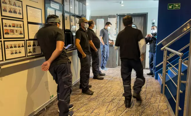 Crew members of the hantavirus-stricken cruise ship, MV Hondius, wait their turns for a first interview with epidemiologists, during the voyage to Spain's port of Tenerife, May 6, 2026. (AP Photo)
