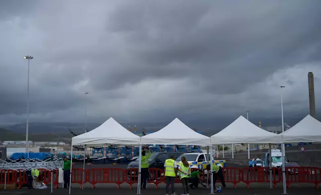 Workers set up temporary shelters in the area where passengers from the MV Hondius cruise ship are expected to arrive at the port of Granadilla in Tenerife, Canary Islands, Spain, Saturday, May 9, 2026. (AP Photo/Manu Fernandez)