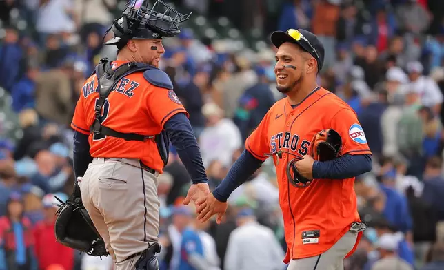 Houston Astros' Christian Vazquez, left, celebrates with Isaac Paredes, right, after a baseball game against the Chicago Cubs on Friday, May 22, 2026, in Chicago. (AP Photo/Melissa Tamez)