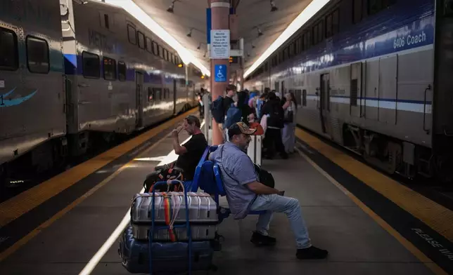 Travelers wait to board an Amtrak train at Union Station in Los Angeles, Wednesday, May 20, 2026. (AP Photo/Jae C. Hong)