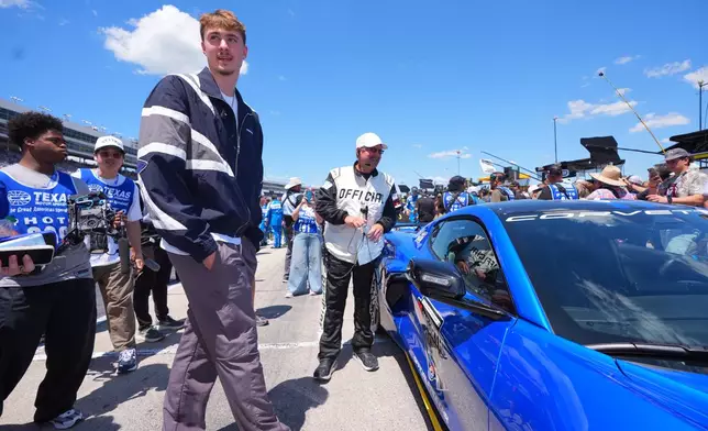 Honorary pace car driver Dallas Mavericks forward Cooper Flagg, center left, prepares for a NASCAR Cup Series auto race at Texas Motor Speedway in Fort Worth, Texas, Sunday, May 3, 2026. (AP Photo/LM Otero)