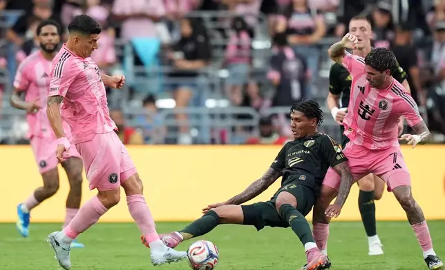 Portland Timbers forward Antony Alves Santos, center, comes under pressure from Inter Miami midfielder Rodrigo de Paul, right, and forward Luis Suarez, left, during the first half of an MLS soccer match, Sunday, May 17, 2026, in Miami. (AP Photo/Rebecca Blackwell)