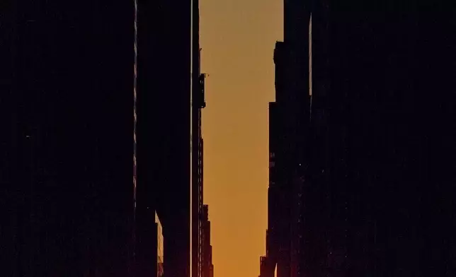 The setting sun is framed between buildings during Manhattanhenge along 42nd Street, Thursday, May 28, 2026, in New York. (AP Photo/Andres Kudacki)