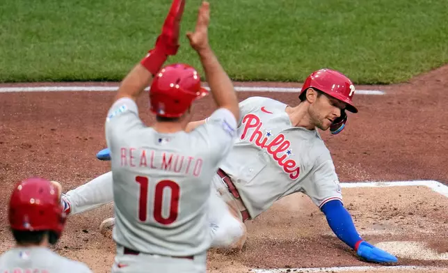 Philadelphia Phillies' Trea Turner, right, scores the second of two runs on a single by Kyle Schwarber off Pittsburgh Pirates pitcher Bubba Chandler during the second inning of a baseball game in Pittsburgh, Saturday, May 16, 2026. (AP Photo/Gene J. Puskar)