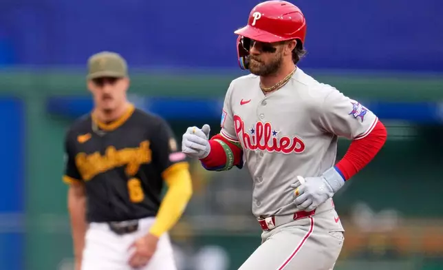 Philadelphia Phillies' Bryce Harper, right, rounds the bases past Pittsburgh Pirates shortstop Konnor Griffin, left, after hitting a three-run home run off Pittsburgh Pirates pitcher Bubba Chandler during the first inning of a baseball game in Pittsburgh, Saturday, May 16, 2026. (AP Photo/Gene J. Puskar)
