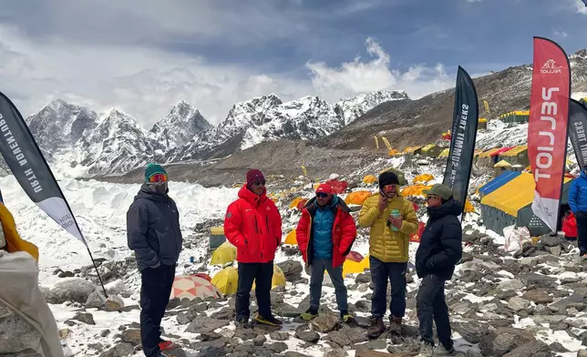 Guides and mountaineers stand outside their tents during acclimatization period before attempting the Mount Everest ascent at the base camp, Nepal, Sunday, May 10, 2026. (AP Photo/Pasang Rinzee Sherpa)