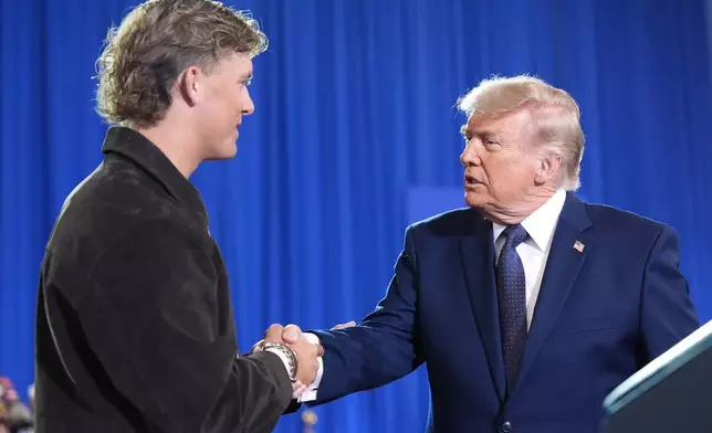 President Donald Trump shakes hands with New York Giants quarterback Jaxson Dart as he arrives to speak at Rockland Community College, Friday, May 22, 2026, in Suffern, N.Y. (AP Photo/Alex Brandon)