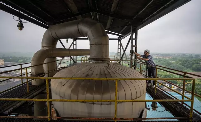 FILE - A technician works on the top deck of a distillery at Bajaj Hindustan Sugar factory that produces ethanol, a type of biofuel, in Meerut, India, Aug. 23, 2023. (AP Photo/Altaf Qadri, File)