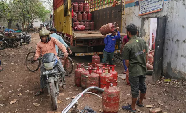 FILE - Workers unload gas cylinders from a truck at a distribution depot in New Delhi, March 19, 2026. (AP Photo/Manish Swarup, File)