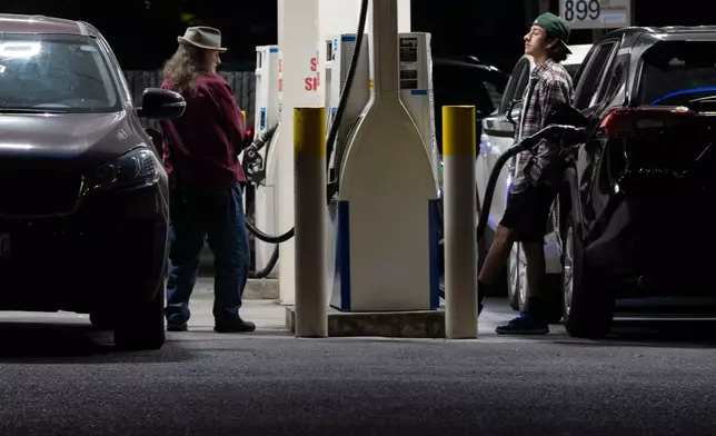 People fill up fuel tanks at a gas station on Wednesday, May 6, 2026, in Portland, Ore. (AP Photo/Jenny Kane)