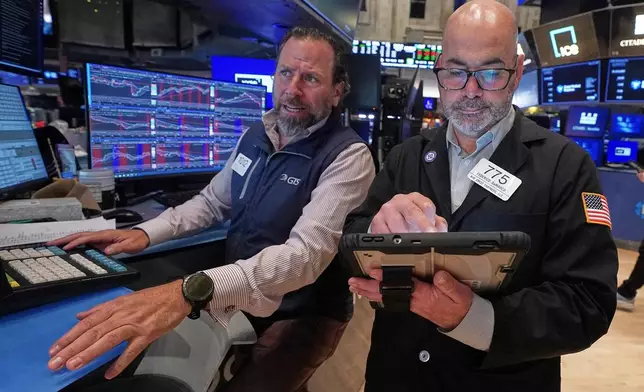 Specialist Michael Pistillo. Left, and trader Fred's Demarco work on the floor of the New York Stock Exchange, Wednesday, May 13, 2026. (AP Photo/Richard Drew)