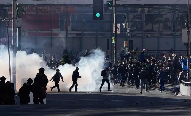 Artisanal minersclash with police during a protest demanding access to expanded mining areas in La Paz, Bolivia, Thursday, May 14, 2026. (AP Photo/Juan Karita)