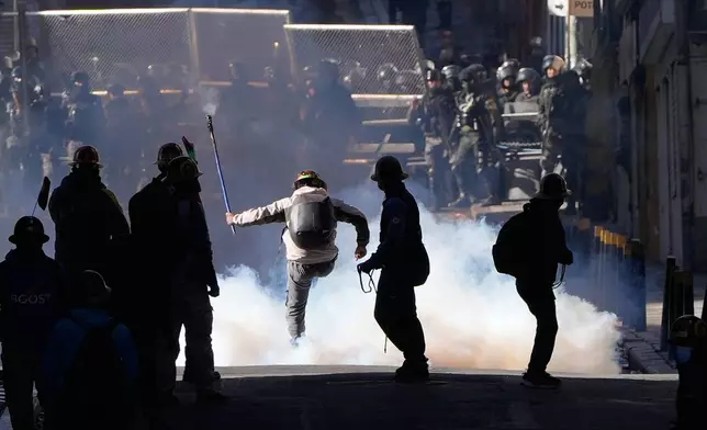 Artisanal miners clash with police demanding access to expanded mining areas in La Paz, Bolivia, Thursday, May 14, 2026. (AP Photo/Juan Karita)