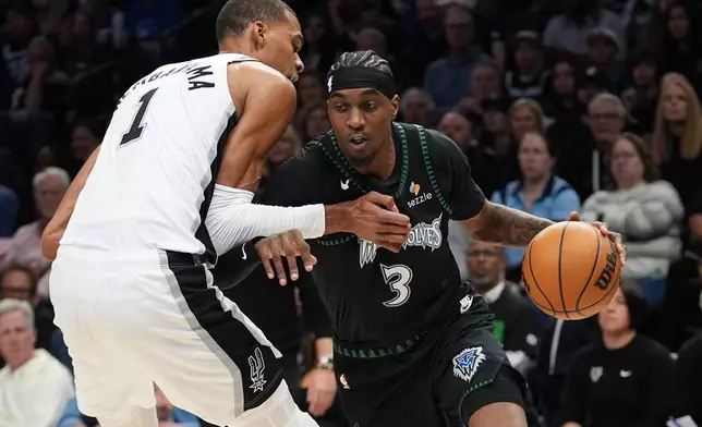 Minnesota Timberwolves forward Jaden McDaniels (3) drives against San Antonio Spurs forward Victor Wembanyama (1) during the first half of Game 3 of a NBA basketball second-round playoff series in Minneapolis, Friday, May 8, 2026. (AP Photo/Abbie Parr)