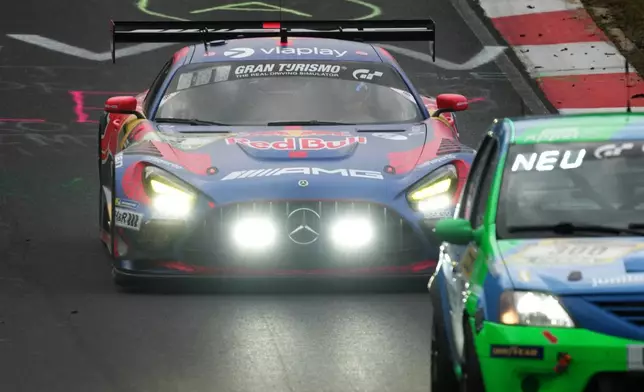 Max Verstappen, driving the Red Bull Mercedes AMG GT3, flashes his his headlights as he demands a clear path from a slower vehicle during the Nurburgring 24-hour auto race in Nurburg, Germany, Saturday May 16, 2026. (Thomas Frey/dpa via AP)