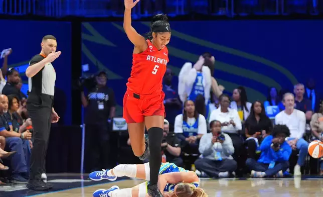 Atlanta Dream forward Angel Reese (5) jumps over a fallen Dallas Wings guard Paige Bueckers during the first half of a WNBA basketball game in Arlington, Texas, Tuesday, May 12, 2026. (AP Photo/LM Otero)