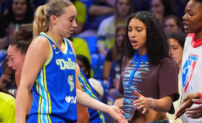 Dallas Wings guard Paige Bueckers (5) gets supports from injured teammate guard Azzi Fudd on the bench during the first half of a WNBA basketball game against the Atlanta Dream in Arlington, Texas, Tuesday, May 12, 2026. (AP Photo/LM Otero)